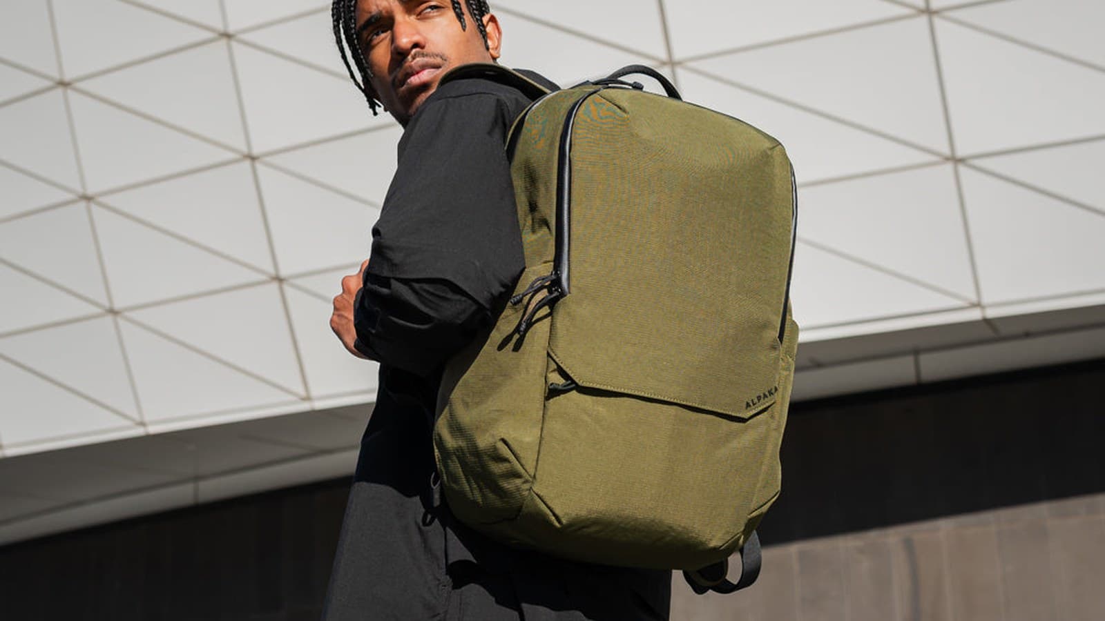 Sac à dos Alpaka Elements Backpack Pro vert olive porté sur une épaule, sous une verrière