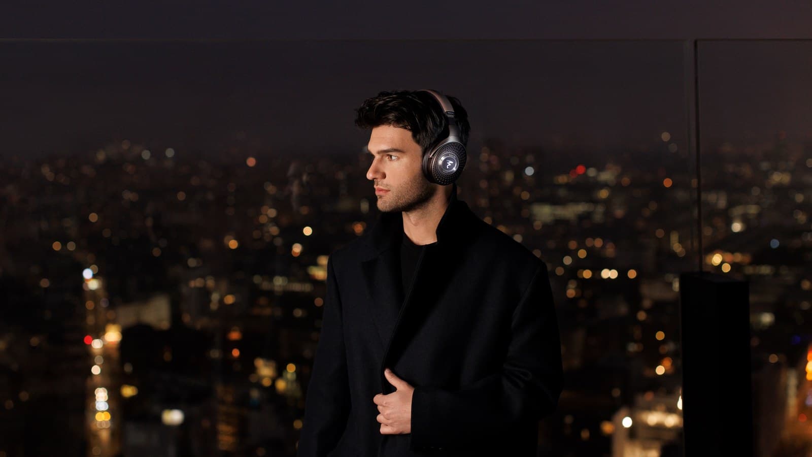 Homme portant un casque Focal Bathys MG la nuit en ville