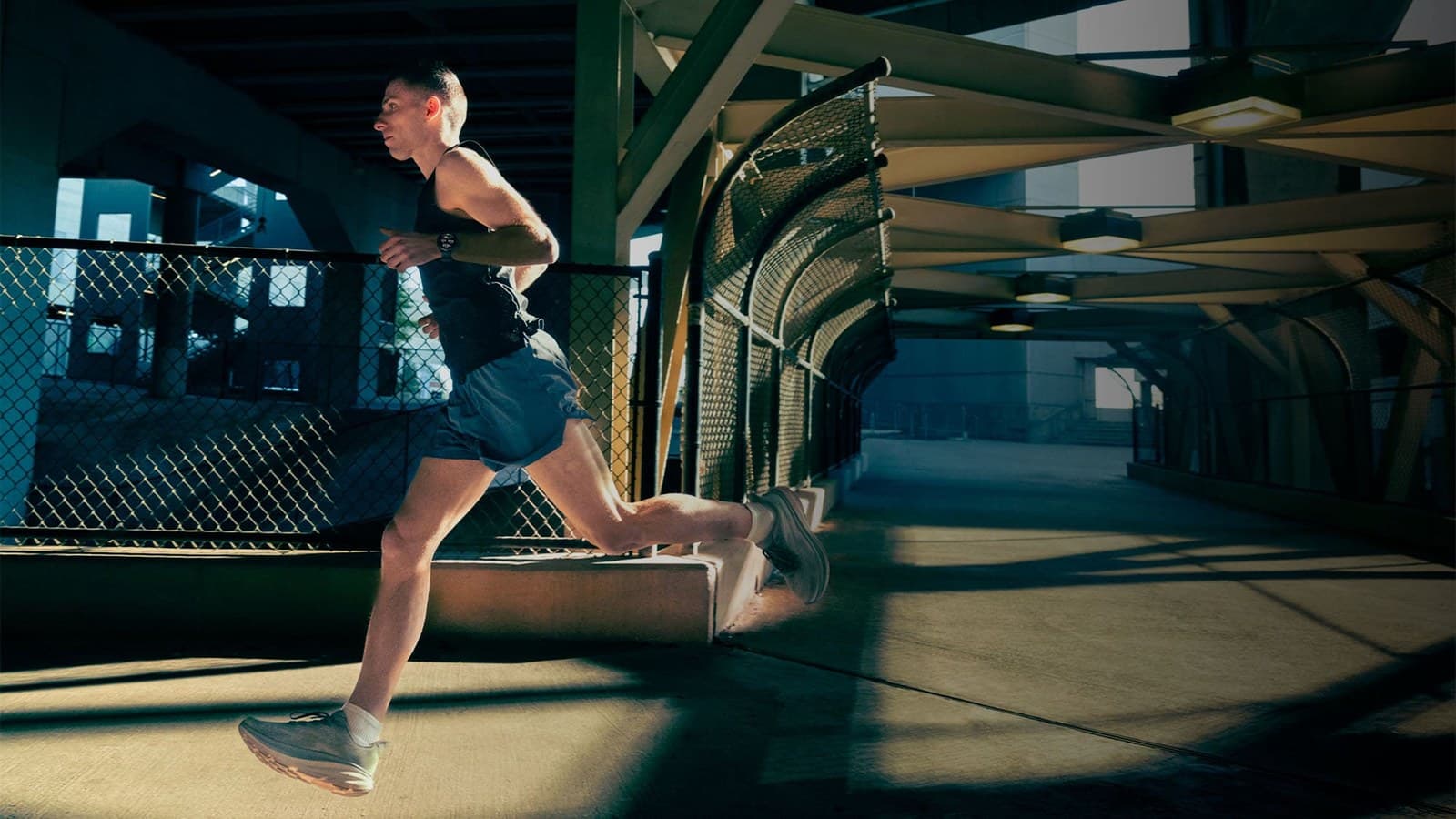 Coureuse sous une passerelle métallique, Garmin Forerunner 970 au poignet