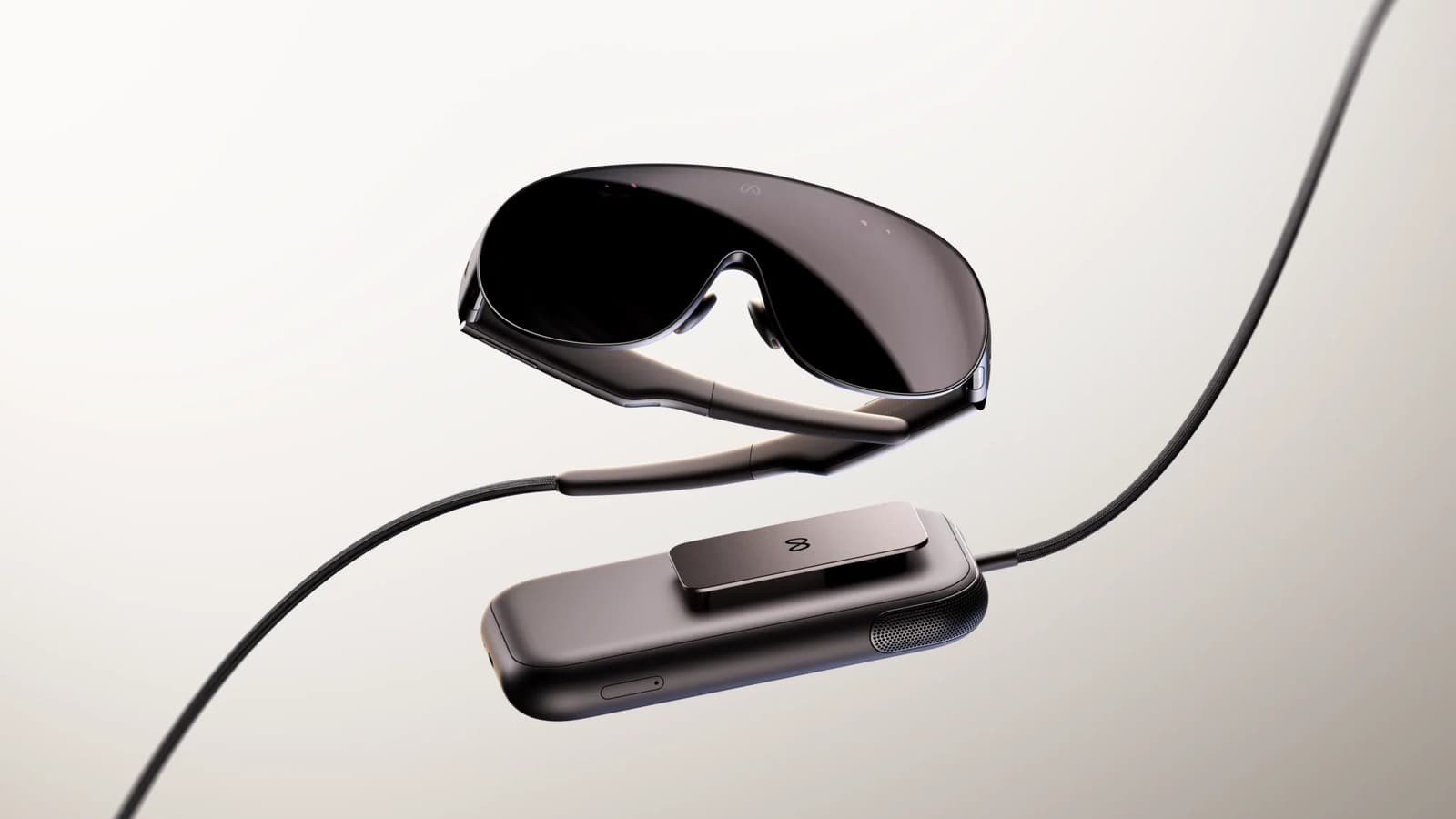 Meta VR Glasses posées à plat, avec leur boîtier de calcul relié par un câble optique