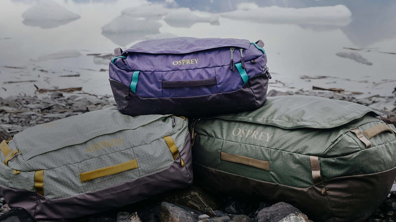 Sacs d'expédition posés au sol devant un paysage de montagne enneigé