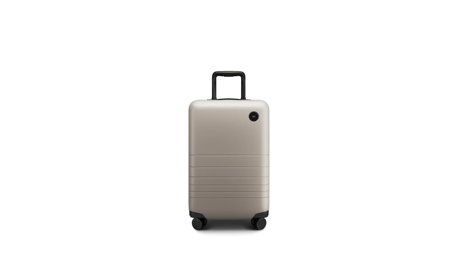 Valise cabine rigide beige à quatre roues, poignée télescopique sortie
