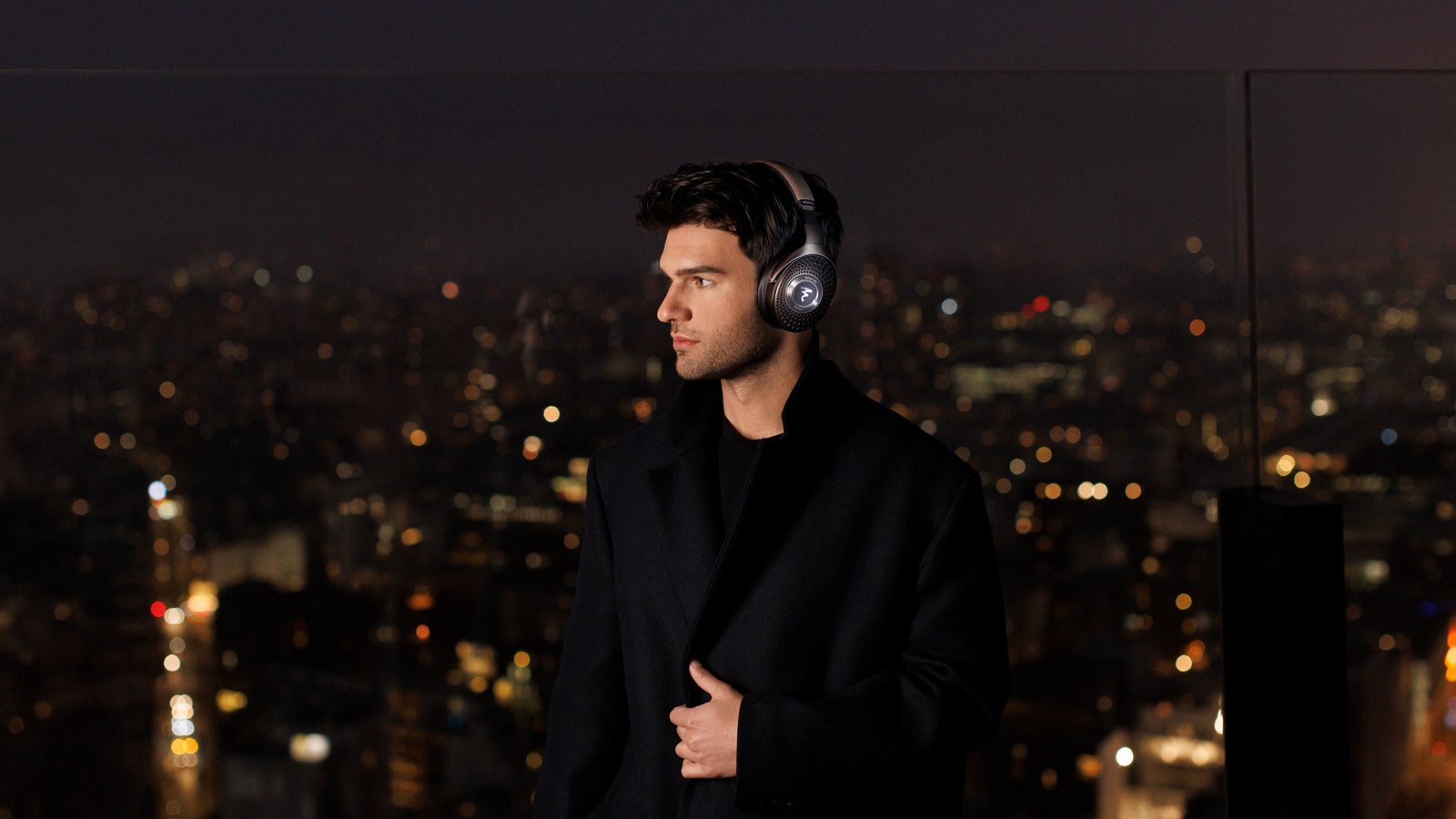 Homme portant un casque Focal Bathys MG la nuit en ville