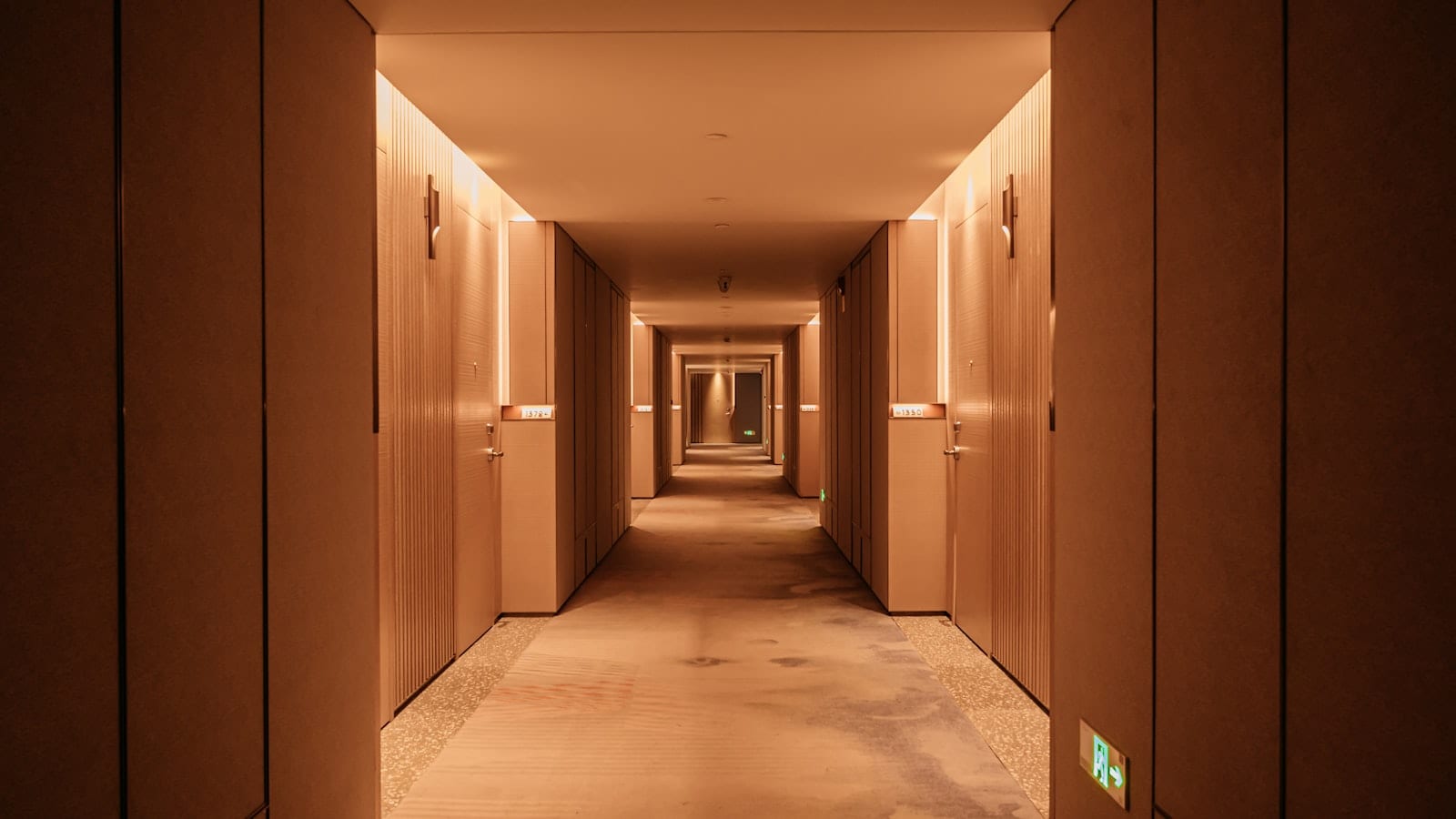 Plan d'étage d'un hôtel affiché près d'un ascenseur, avec numérotation des chambres visible