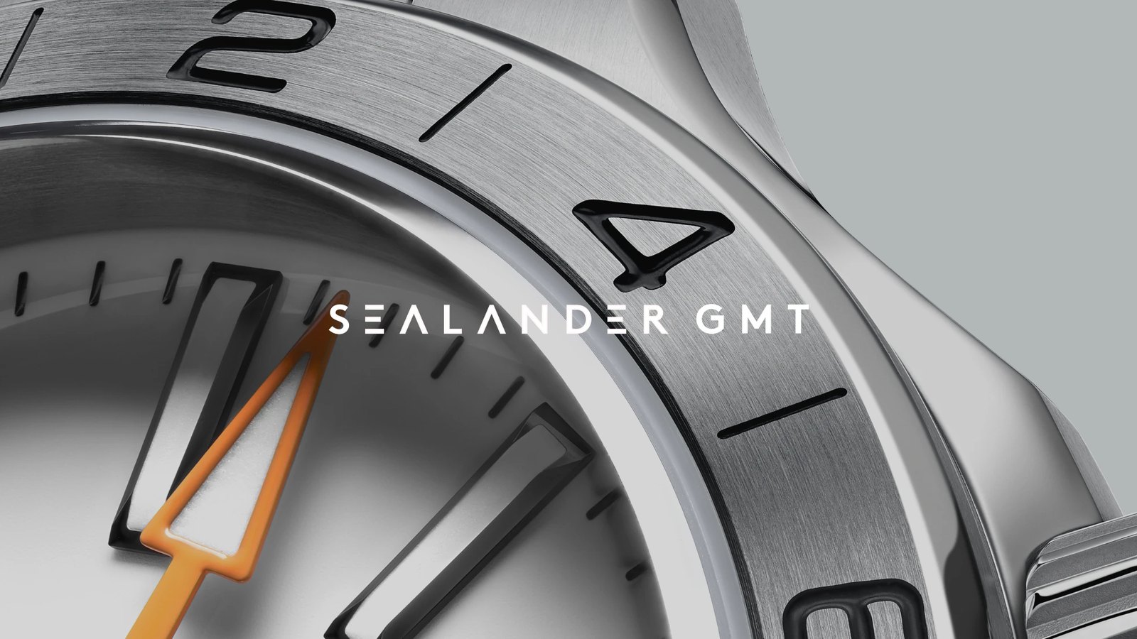Lunette et aiguille GMT orange de la Christopher Ward C63 Sealander GMT en gros plan, cadran bleu glacier et graduation 24 heures gravee