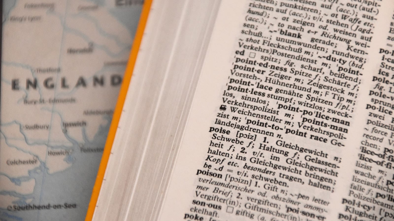 Écran d'ordinateur portable affichant un e-mail professionnel en français et sa traduction anglaise côte à côte, avec un chronomètre posé sur le bureau.