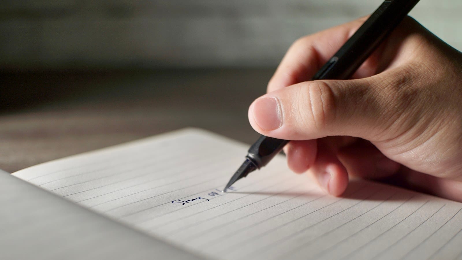 Une note manuscrite de cinq lignes numérotées posée sur un bureau, à côté d'un ordinateur portable ouvert sur une messagerie et d'une tasse de café.