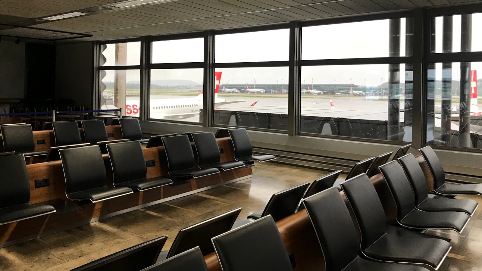 Écran d'ordinateur portable affichant un portail captif d'aéroport dans une salle d'embarquement, un smartphone posé à côté