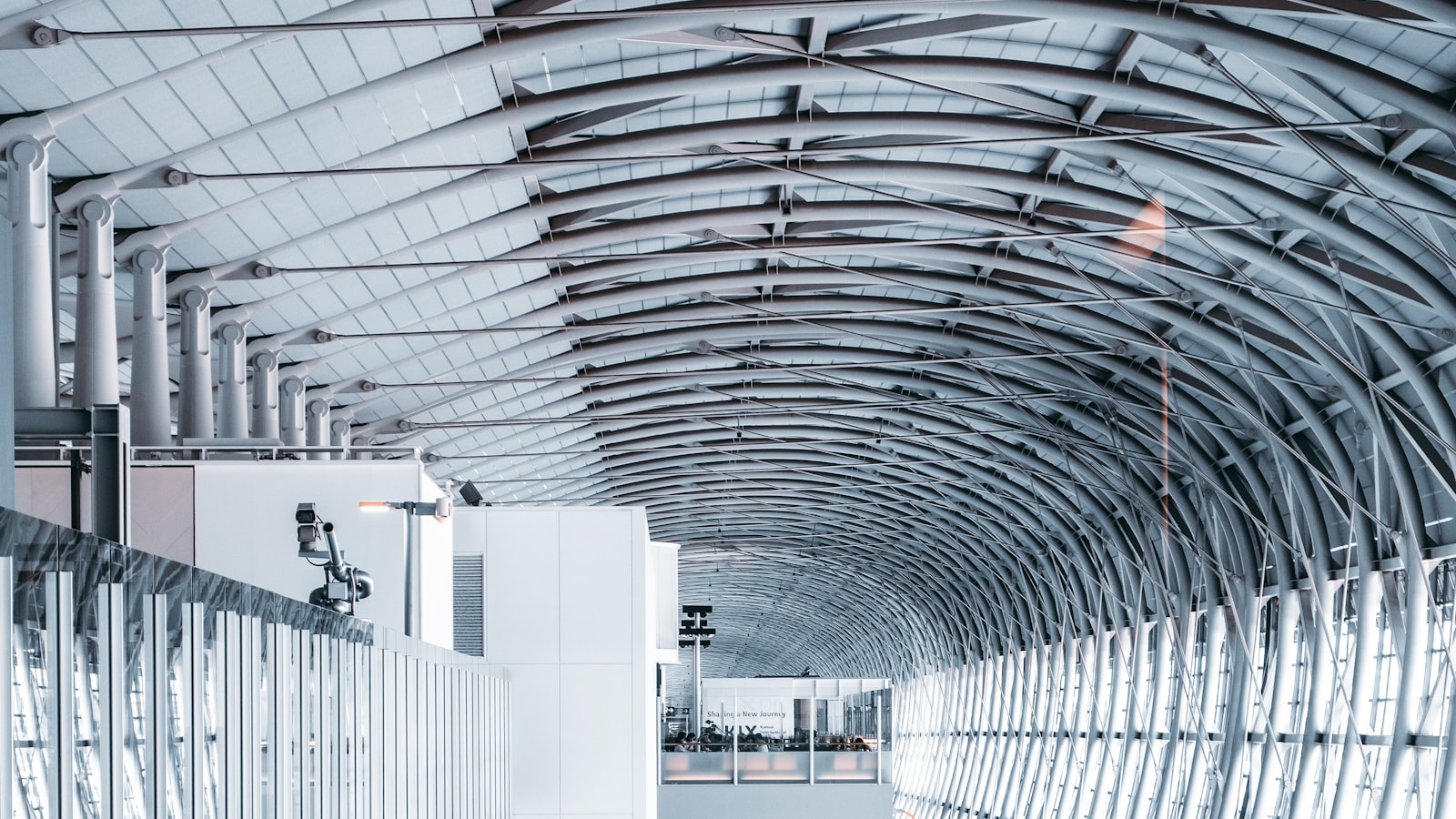 Écran d'affichage d'aéroport indiquant plusieurs vols retardés, avec un voyageur consultant son téléphone au premier plan