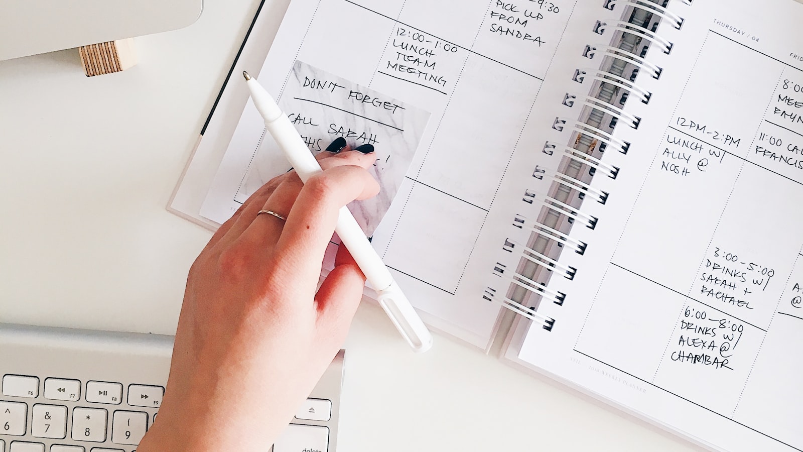 Bureau avec un agenda papier ouvert montrant deux plages horaires surlignées et un téléphone retourné.