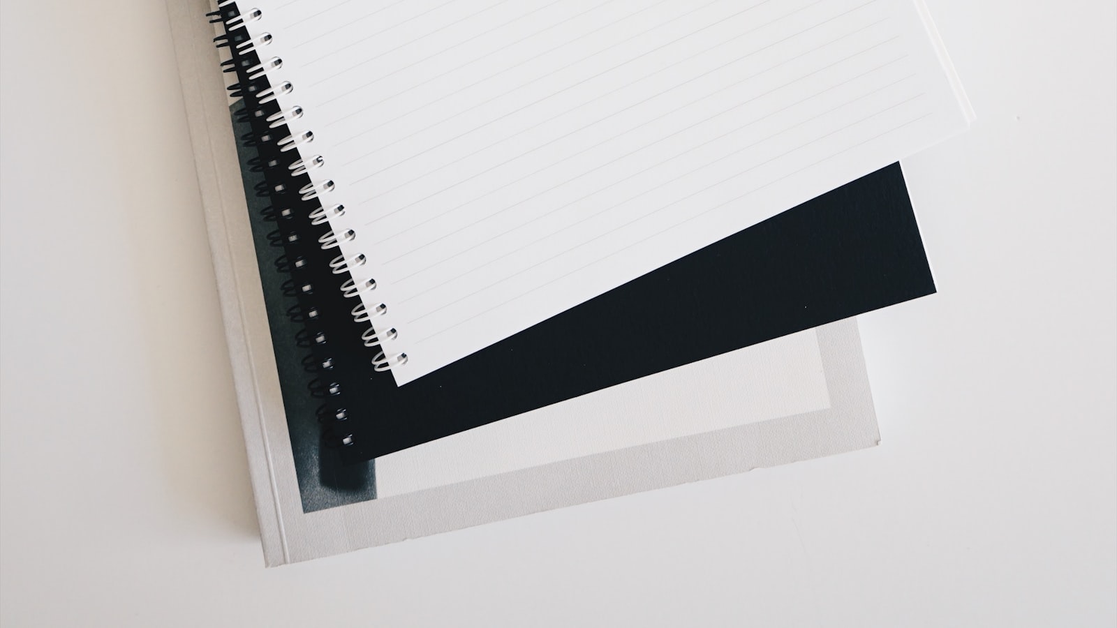Bureau vu de dessus avec un téléphone affichant une liste de tâches, un ordinateur portable ouvert sur un tableau de projets, un carnet annoté et un stylo posé en travers.