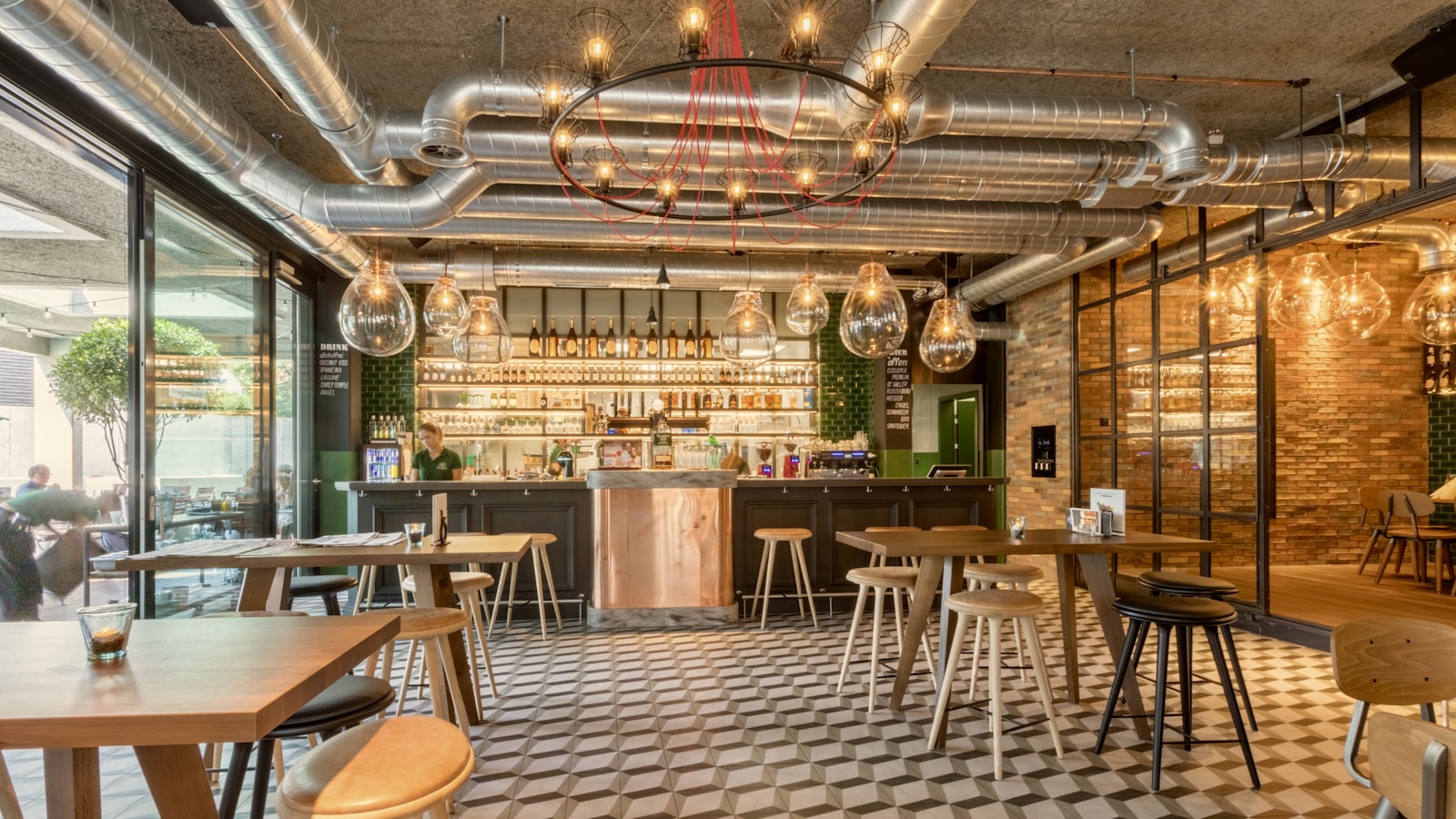 Table de café londonien à 7 h 15, deux tasses, un carnet ouvert et une prise murale visible sous la banquette