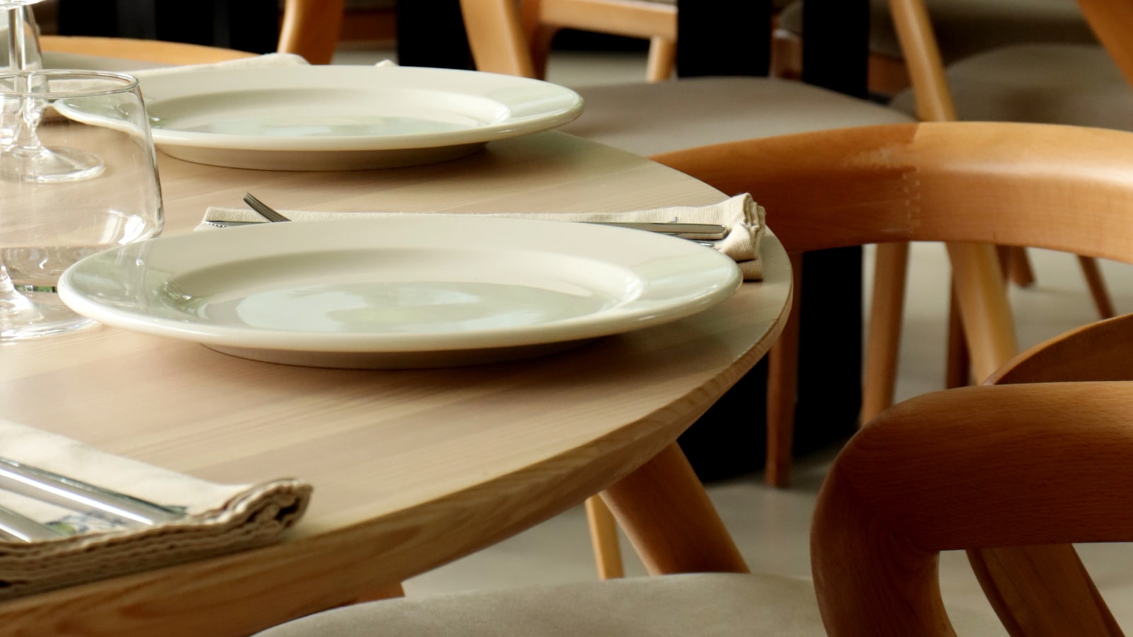 Salle de restaurant au plafond haut en béton, tables serrées, un sonomètre posé sur une nappe blanche