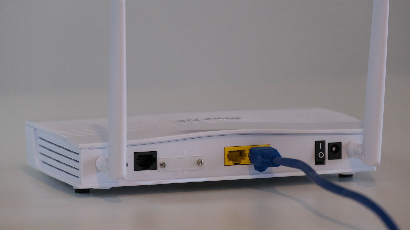 Table d'hôtel avec un ordinateur portable ouvert, une clé de sécurité USB, une carte SIM dans son support et une feuille de codes imprimés